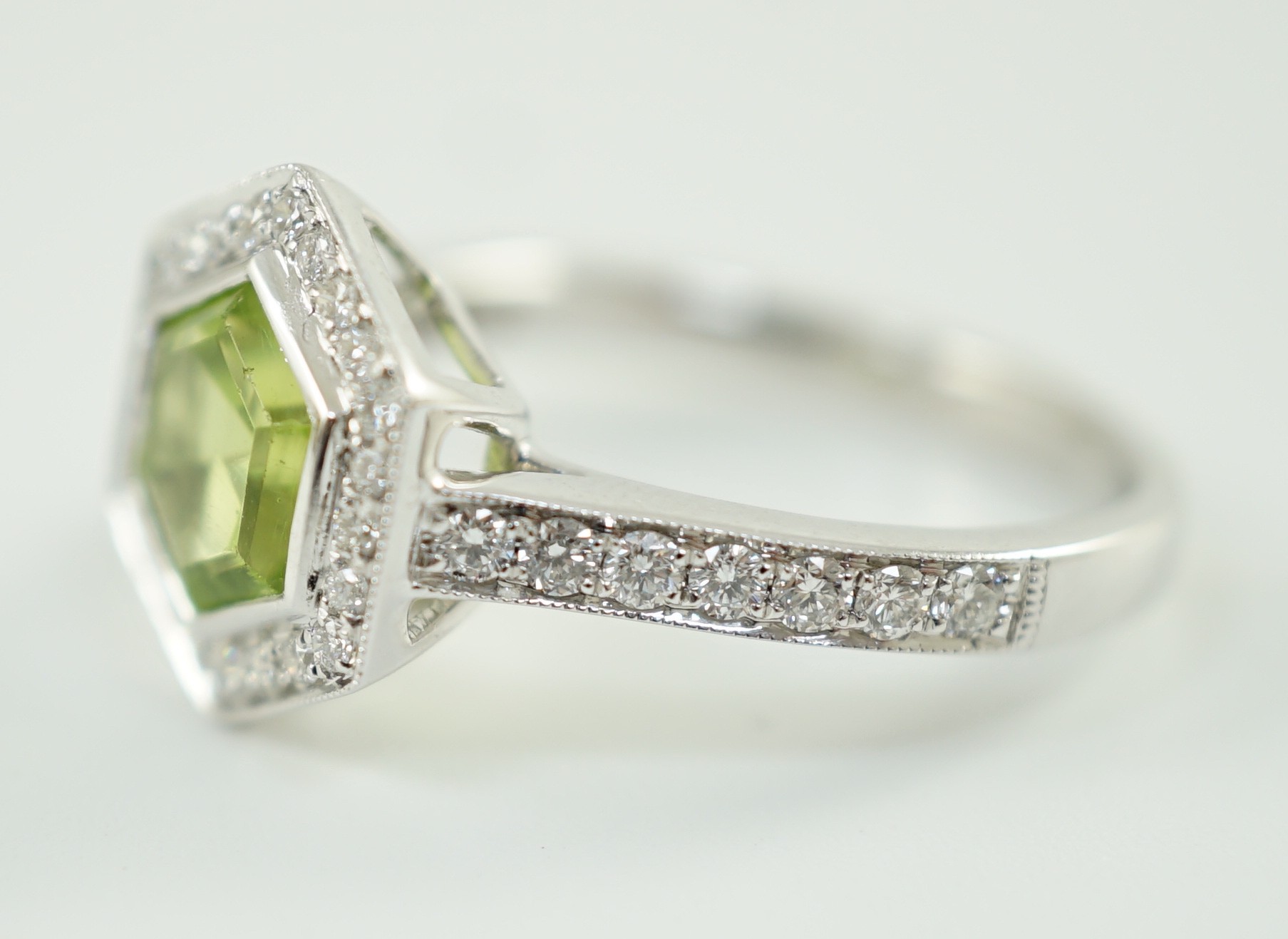 A modern 18ct white gold, peridot and diamond set hexagonal cluster set dress ring